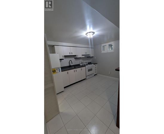 A kitchen with white cabinets and appliances.