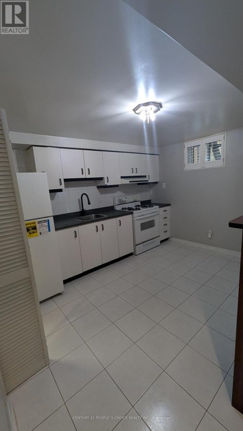 A kitchen with white cabinets and appliances.
