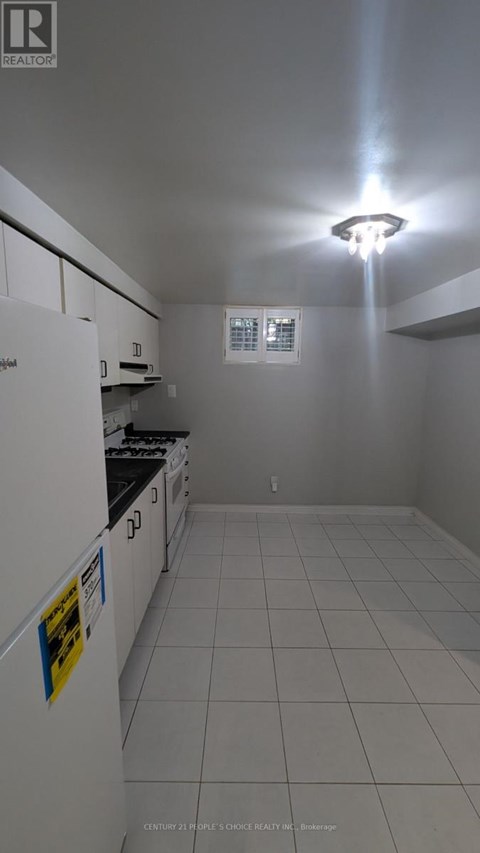 A kitchen with white cabinets and a white fridge.