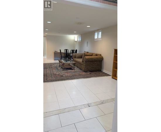 A living room with a brown couch and a rug.