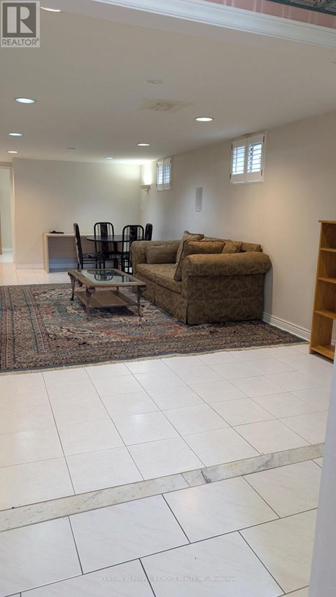 A living room with a brown couch and a rug.