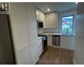 A kitchen with white cabinets and a stainless steel dishwasher.