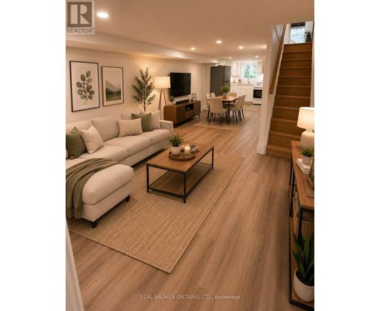 A well-lit living room with a staircase leading to the upper floor.