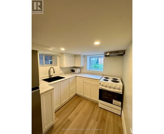 A kitchen with white cabinets and a stove top oven.