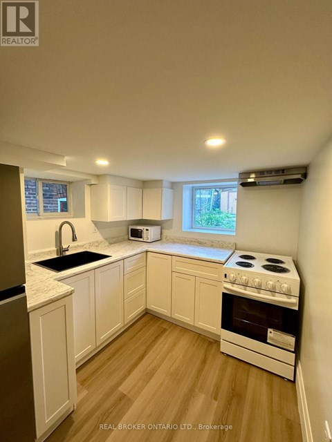 A kitchen with white cabinets and a stove top oven.