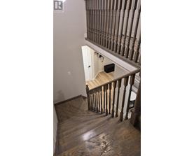 A wooden staircase with a white door at the top.