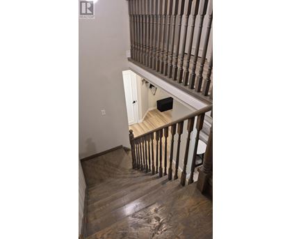 A wooden staircase with a white door at the top.