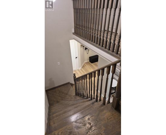 A wooden staircase with a white door at the top.