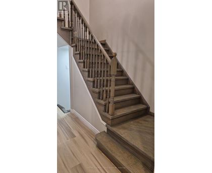 A wooden staircase with a white wall on the side.