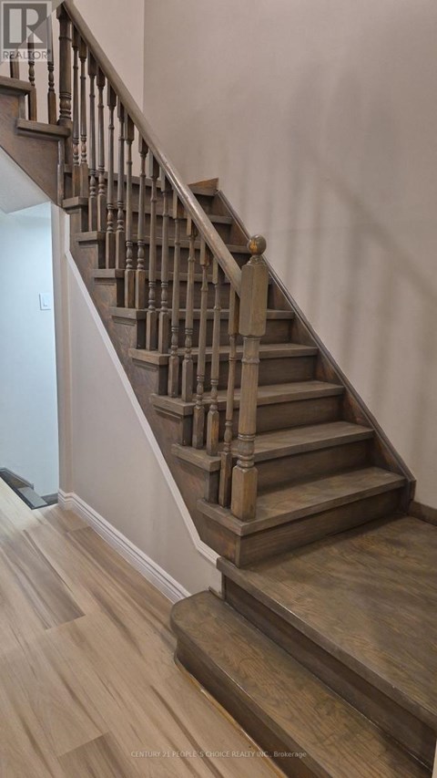 A wooden staircase with a white wall on the side.