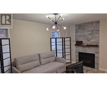 A grey couch is in front of a fireplace in a living room.
