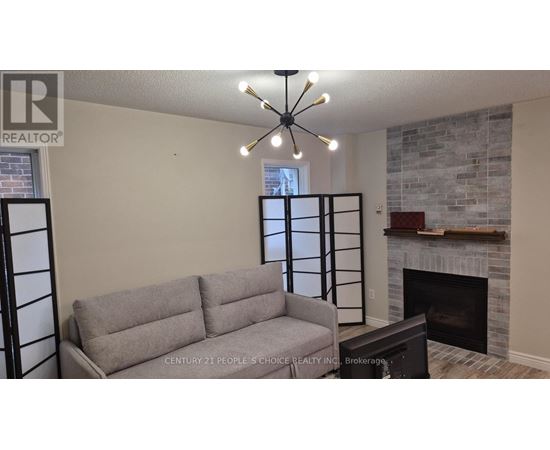 A grey couch is in front of a fireplace in a living room.