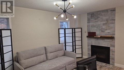 A grey couch is in front of a fireplace in a living room.