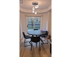 A dining room with a table and chairs.