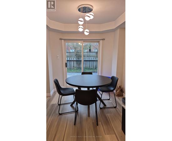 A dining room with a table and chairs.