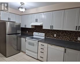 A kitchen with white cabinets and a stainless steel refrigerator.