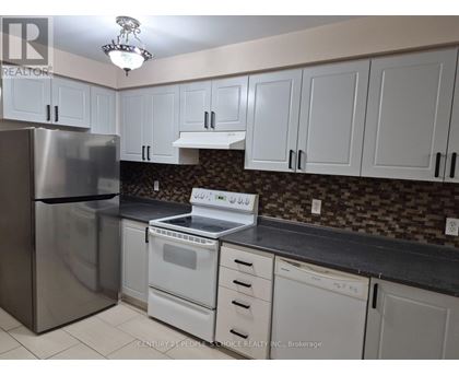 A kitchen with white cabinets and a stainless steel refrigerator.