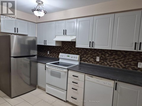 A kitchen with white cabinets and a stainless steel refrigerator.