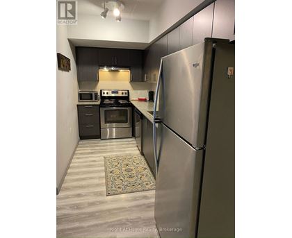 A kitchen with a stainless steel refrigerator and a stove top oven.