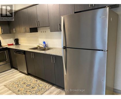 A kitchen with a stainless steel refrigerator and cabinets.