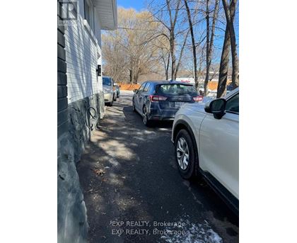 Cars parked on a driveway in front of a house.