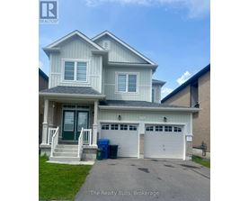 A two-story house with a garage and a driveway in front.