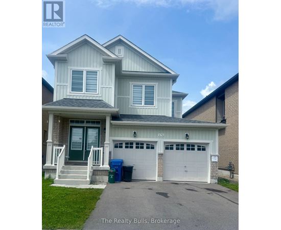 A two-story house with a garage and a driveway in front.
