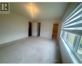 A room with a window on the right side and a door on the left side.