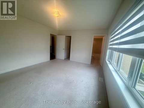 A room with a window on the right side and a door on the left side.