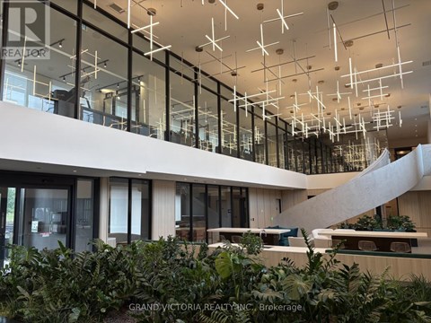 A modern interior space with glass walls and hanging lights.