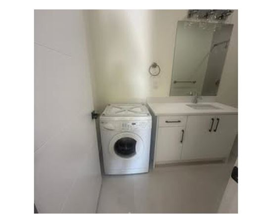 A white washing machine in a small bathroom.