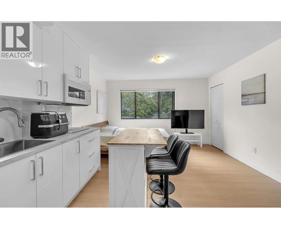 A modern kitchen with white cabinets and a wooden island.