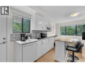 A white kitchen with a black bar stool.