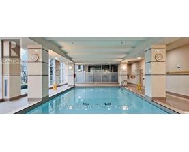 A large indoor swimming pool with a glass bottom.