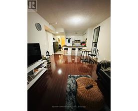 A living room with a television, a couch, and a guitar on the floor.