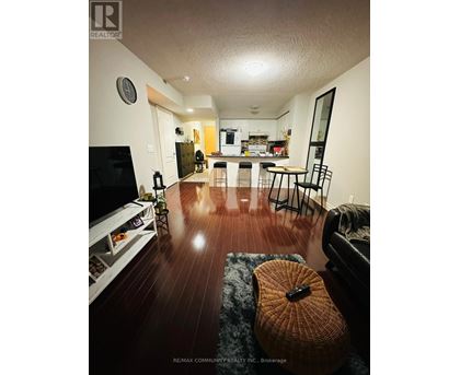 A living room with a television, a couch, and a guitar on the floor.