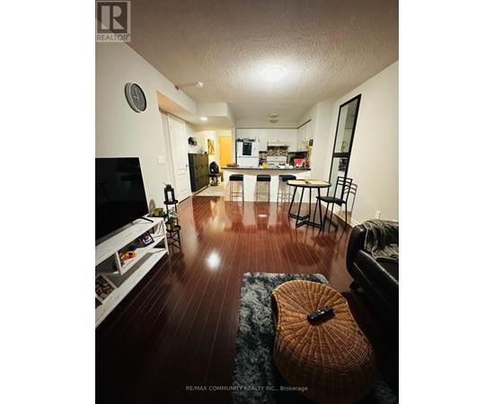 A living room with a television, a couch, and a guitar on the floor.
