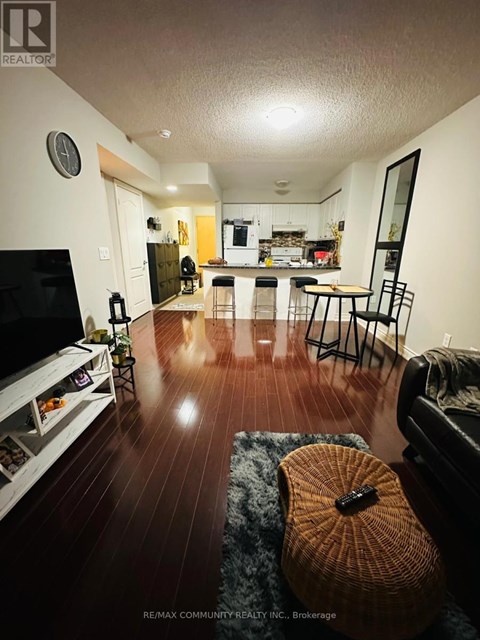 A living room with a television, a couch, and a guitar on the floor.