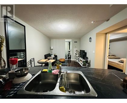 A kitchen with a sink and a mirror.