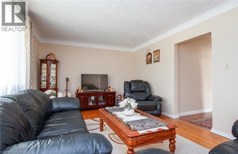 A living room with a black leather couch and a wooden coffee table.
