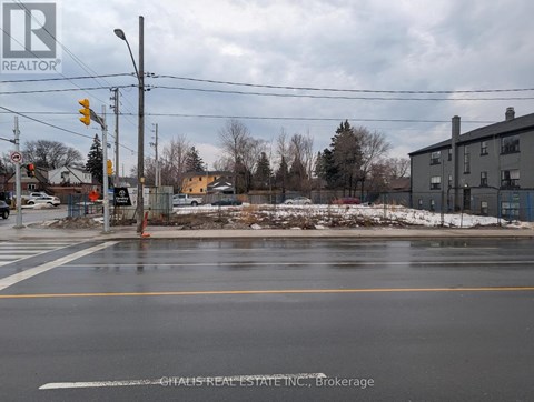 A street view with a traffic light and a building in the background.