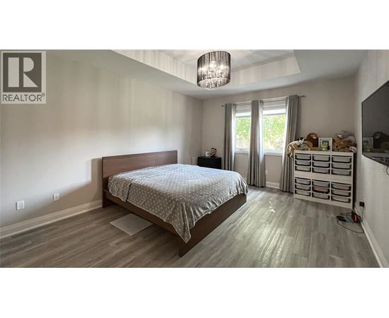 A bedroom with a large bed and a chandelier.
