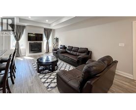 A living room with a black leather couch and a coffee table.