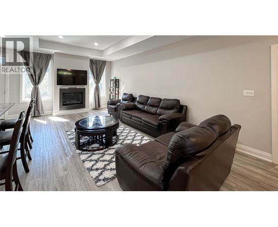 A living room with a black leather couch and a coffee table.