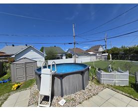 A backyard with a pool and a fence.