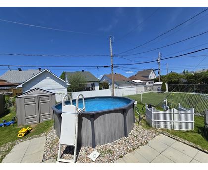 A backyard with a pool and a fence.