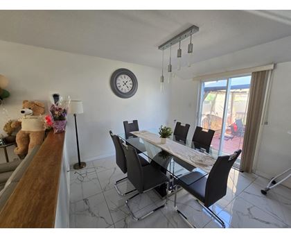 A dining room with a white table and black chairs.