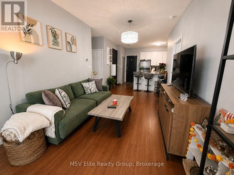 A living room with a green couch and a wooden floor.