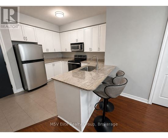 A kitchen with white cabinets and a marble island.