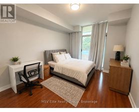 A bedroom with a bed, desk, and chair.